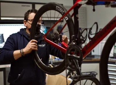 Un homme masqué ajuste une roue de vélo rouge dans un atelier à Montluçon dans l'Allier 03