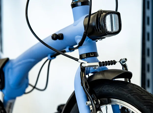 Gros plan d'un vélo bleu clair avec phare, frein avant, et garde-boue à Montluçon dans l'Allier 03